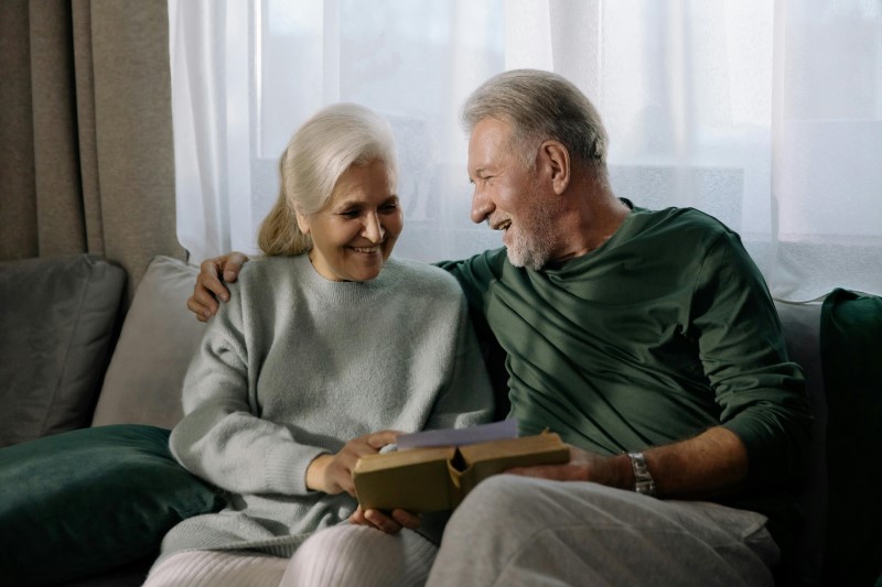 A smiling, healthy-looking couple in their late 50s enjoying a conversation